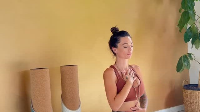 A woman meditates in a calm setting, with Mache yoga mat tubes kept nearby.