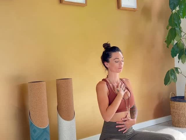 A woman meditates in a calm setting, with Mache yoga mat tubes kept nearby.