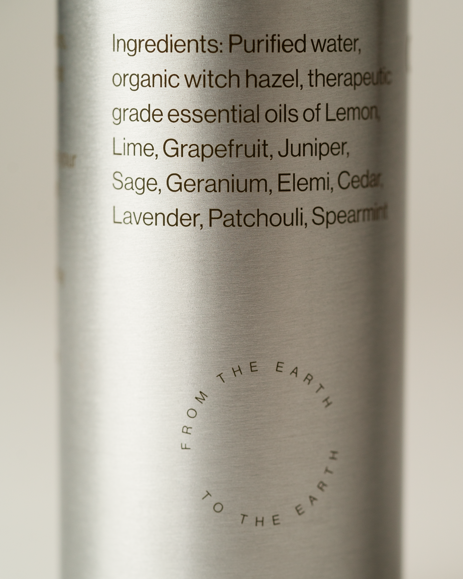 Silver bottle with yoga mat spray ingredient list on a light background