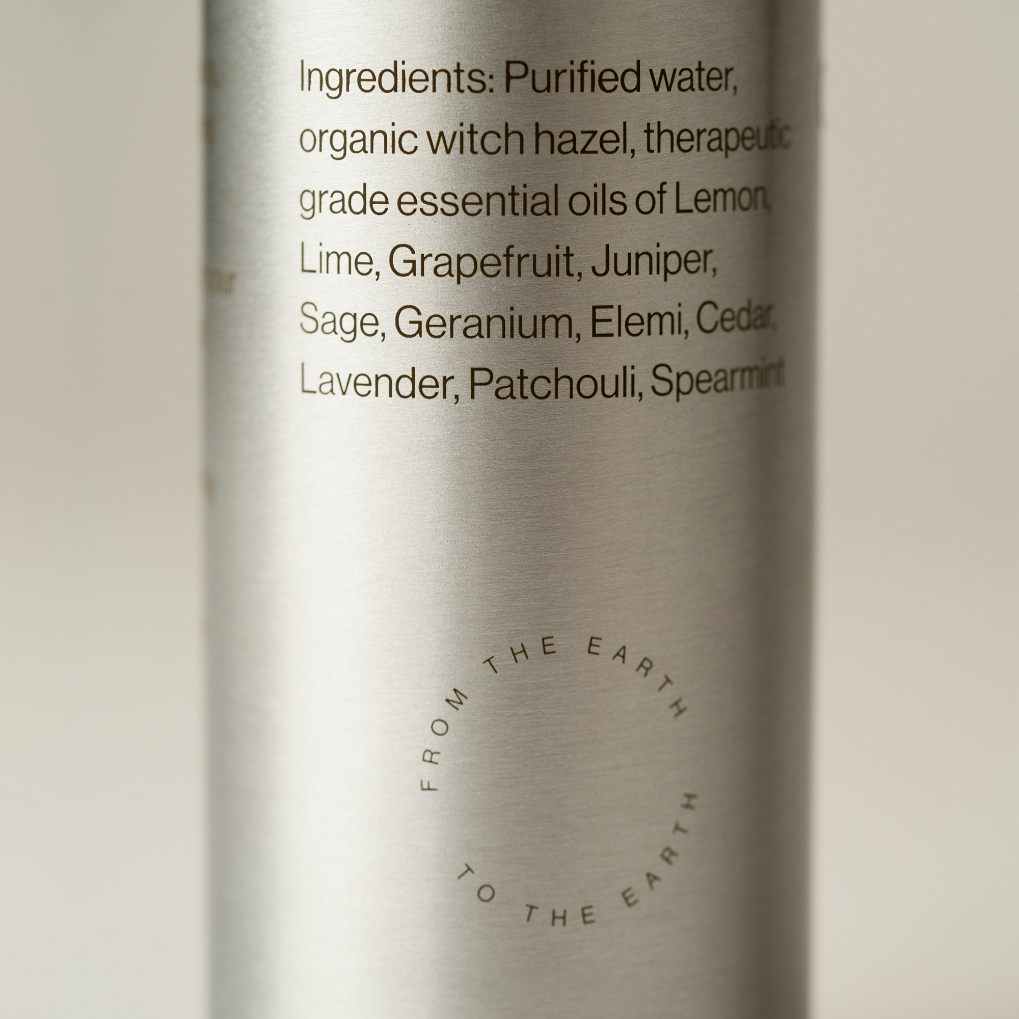 Silver bottle with yoga mat spray ingredient list on a light background