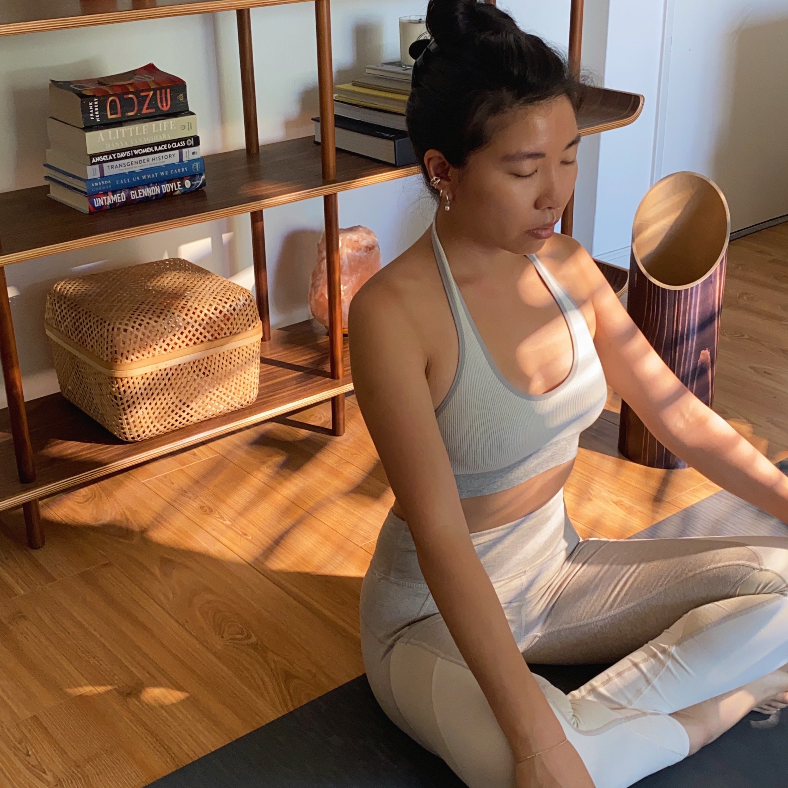 Person doing yoga at home beside their yoga mat storage