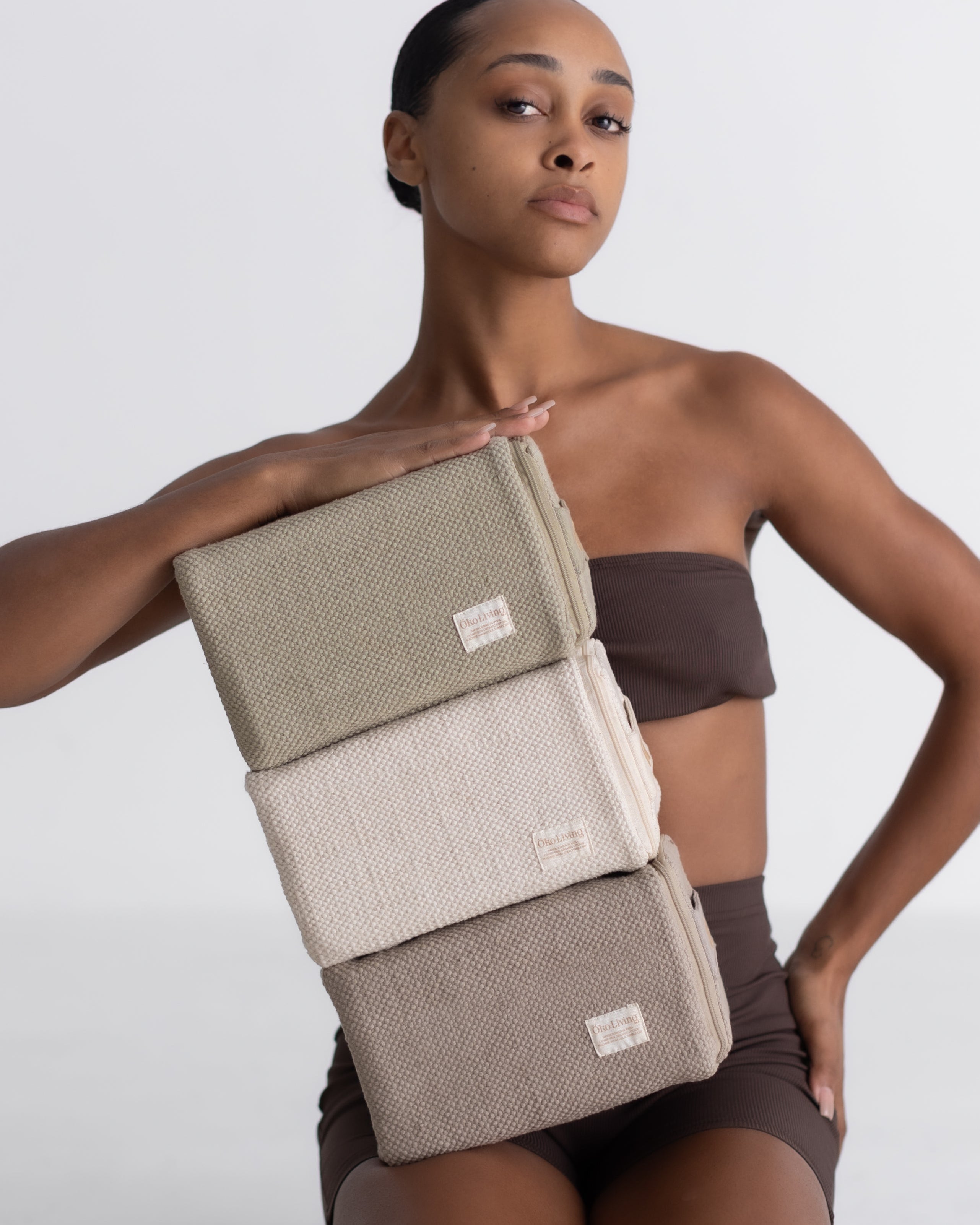 Woman holding cotton yoga blocks on a white background
