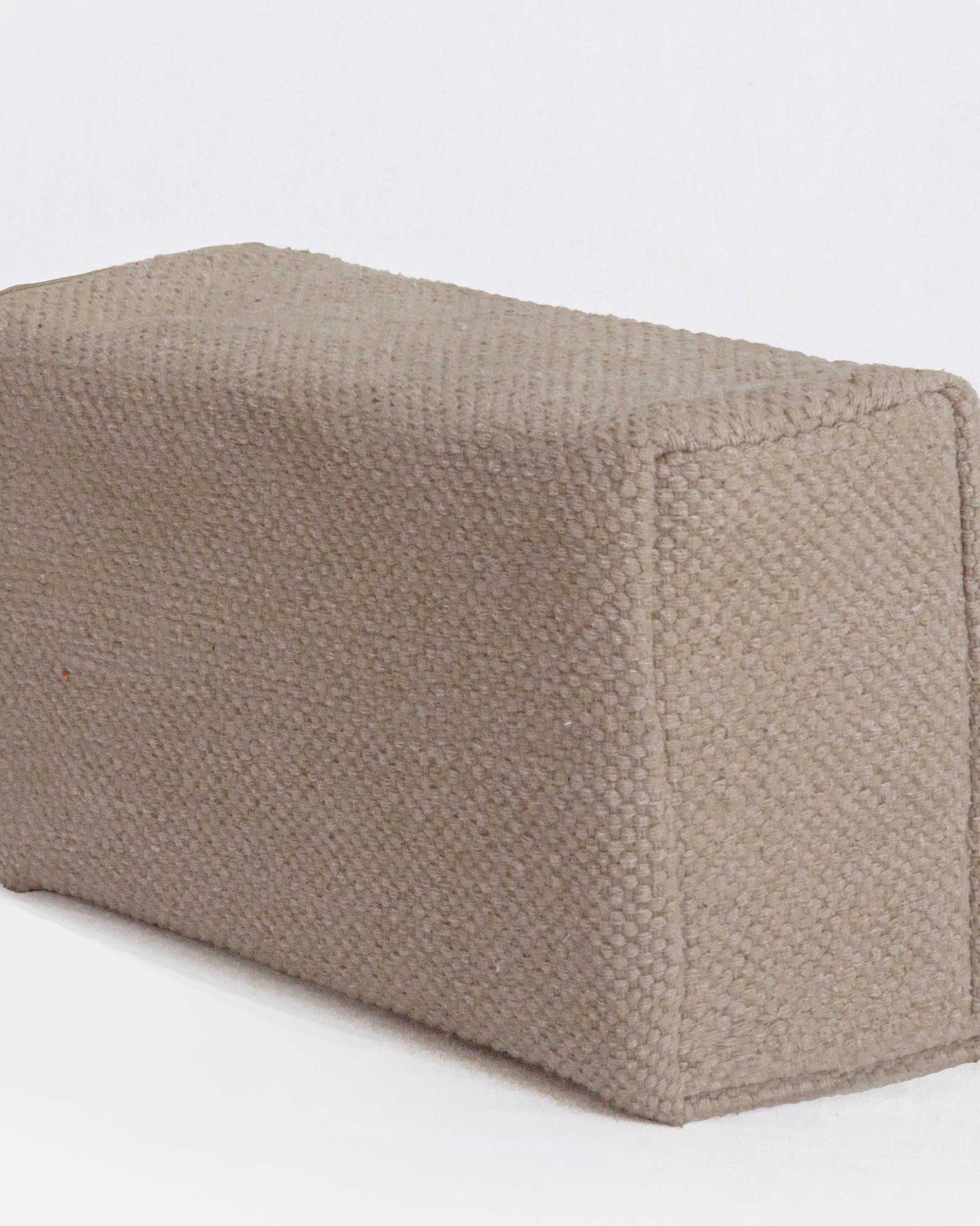 Textured beige yoga block on a white background