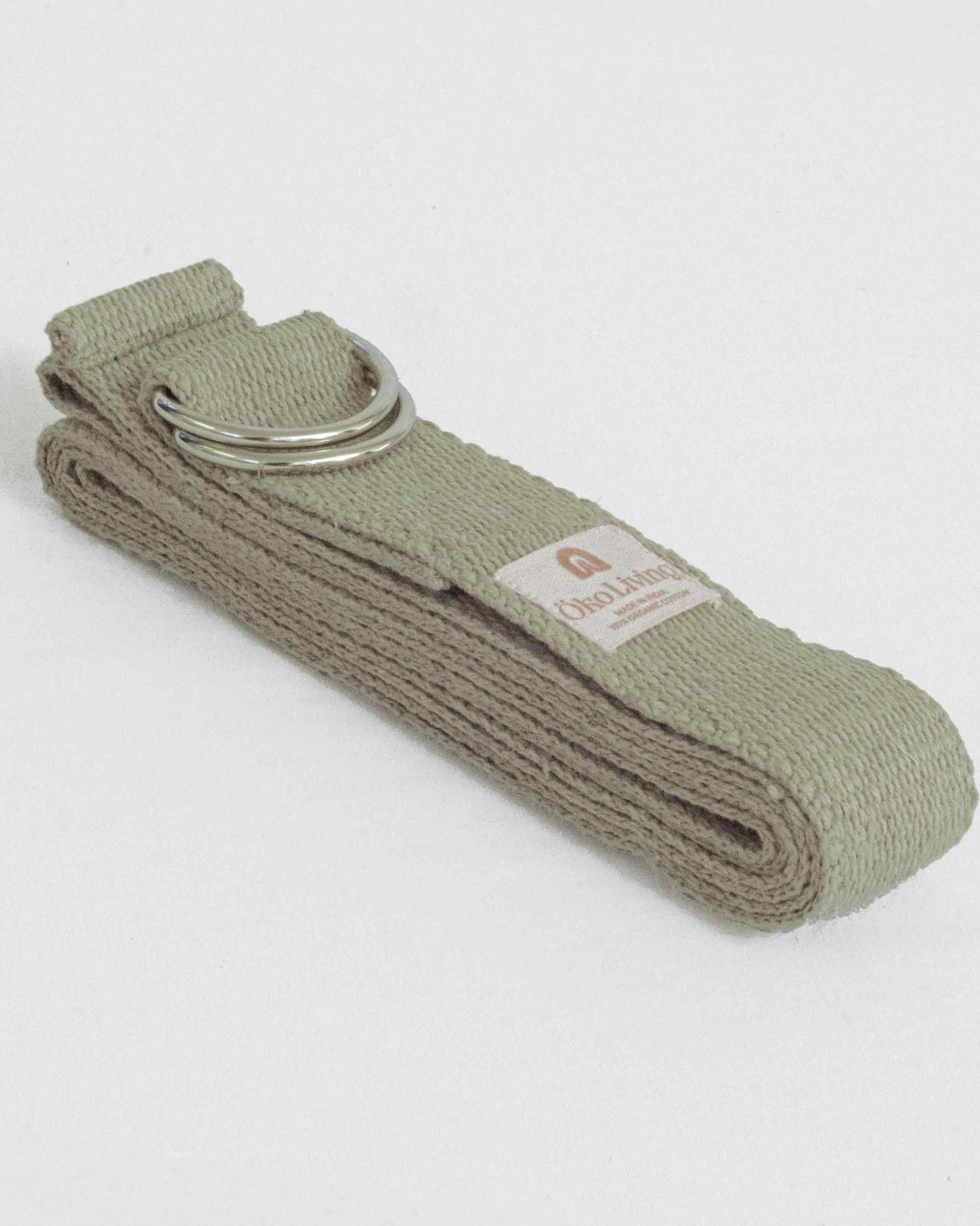 Green yoga belt with a metal ring on a light gray background