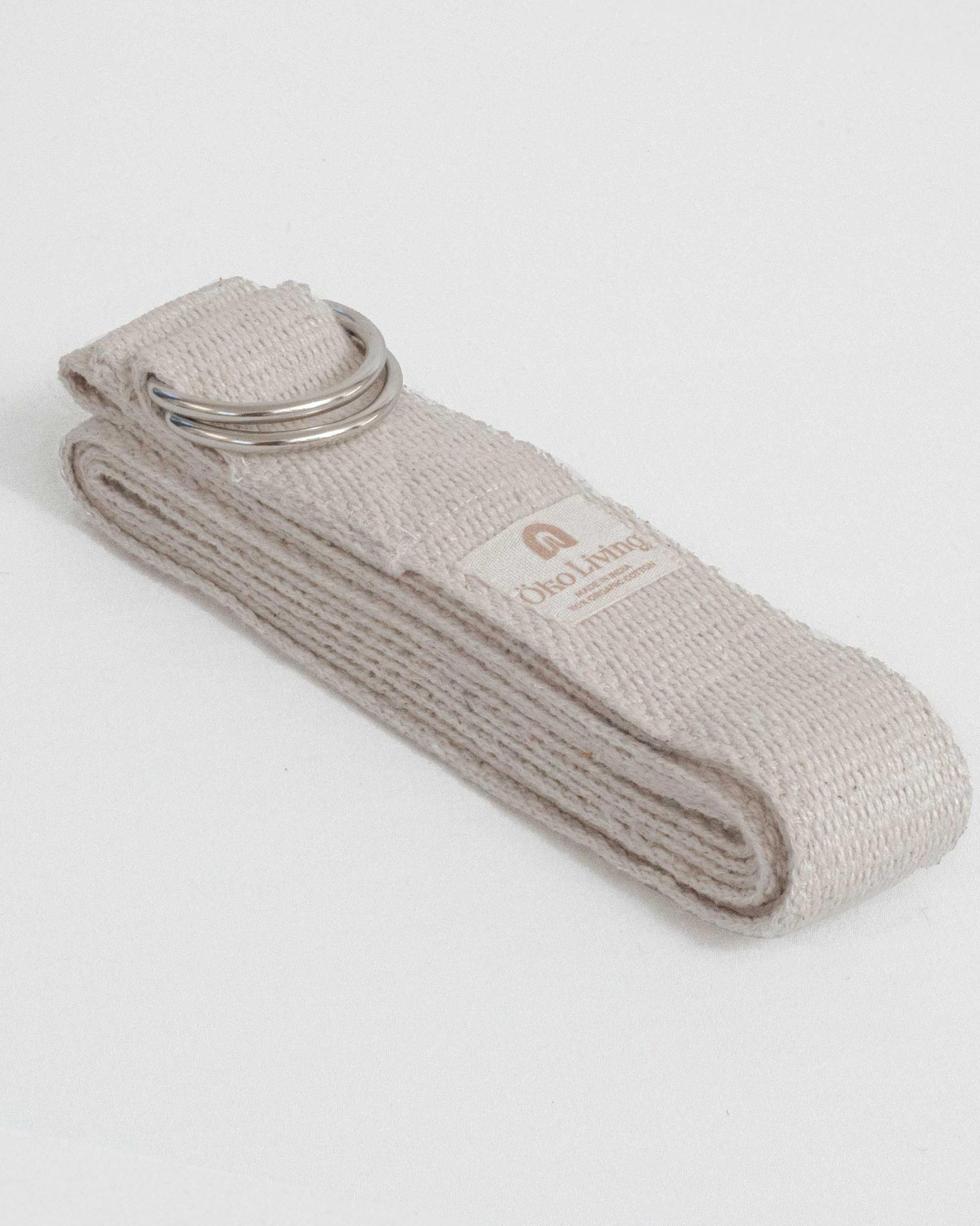 Beige yoga belt with a metal buckle on a light gray background