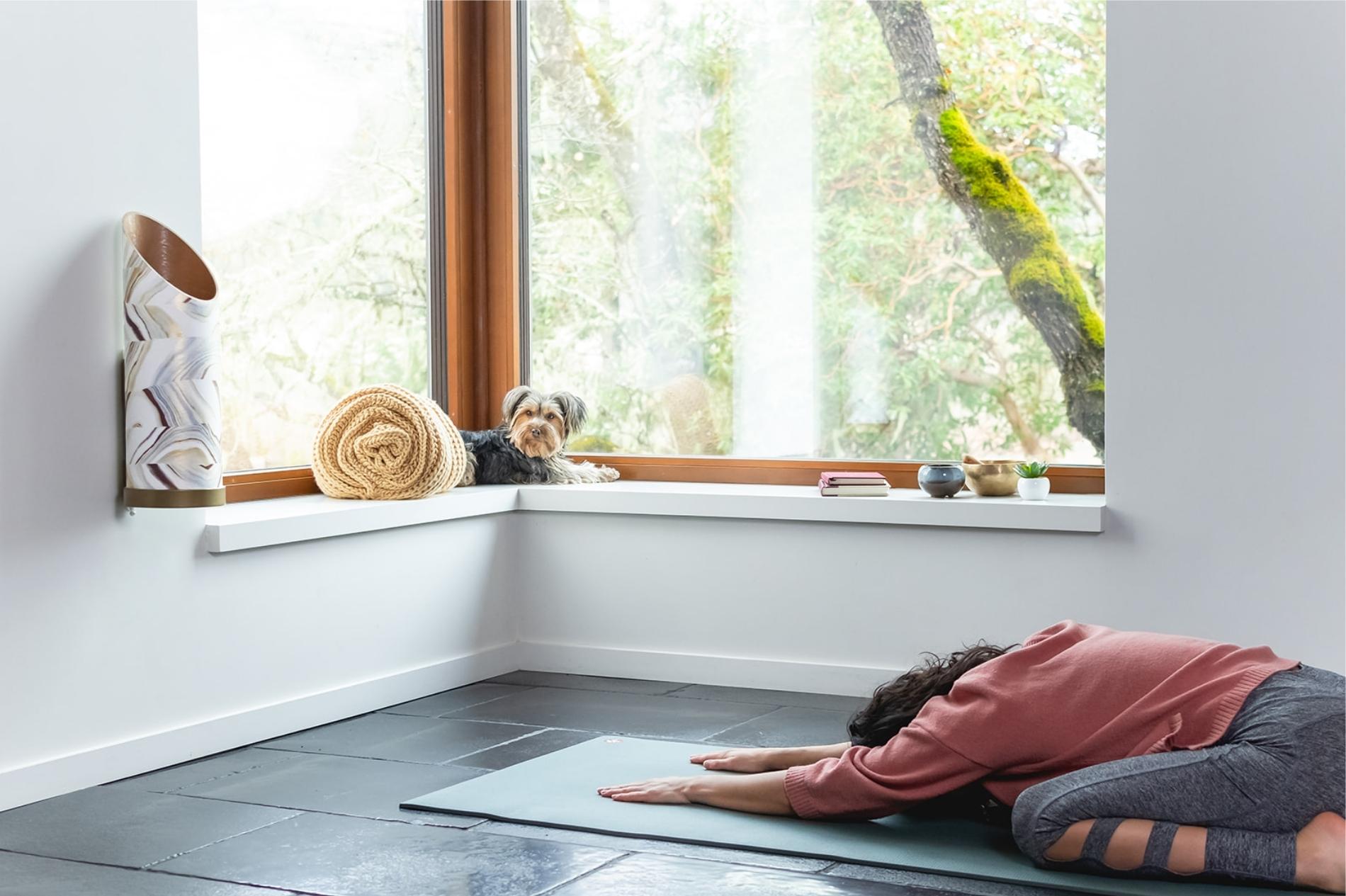 WOMAN PRACTICING YOGA IN HOME STUDIO WITH SUSTAINABLE PROP STORAGE