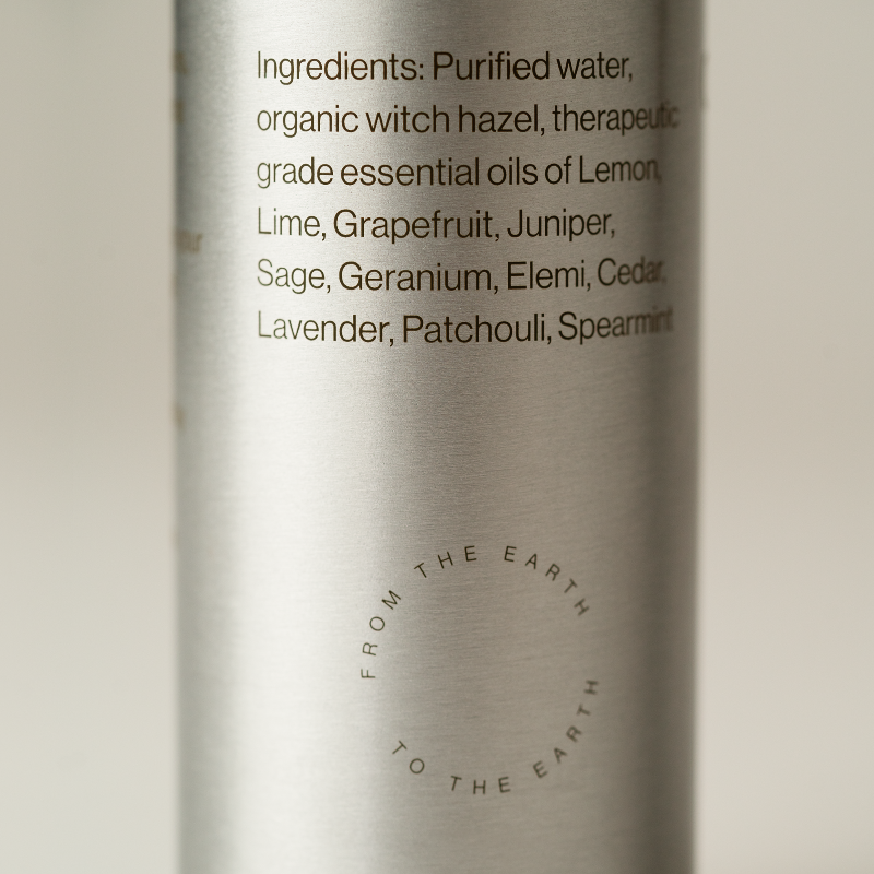 Silver bottle with text listing ingredients on a light background