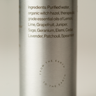 Silver bottle with text listing ingredients on a light background