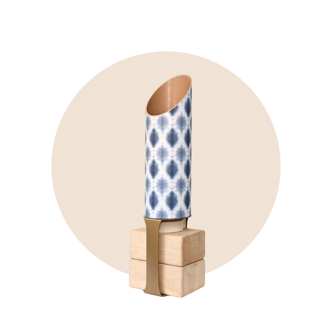 Decorative wall hook with a blue and white patterned cylindrical object on a beige background