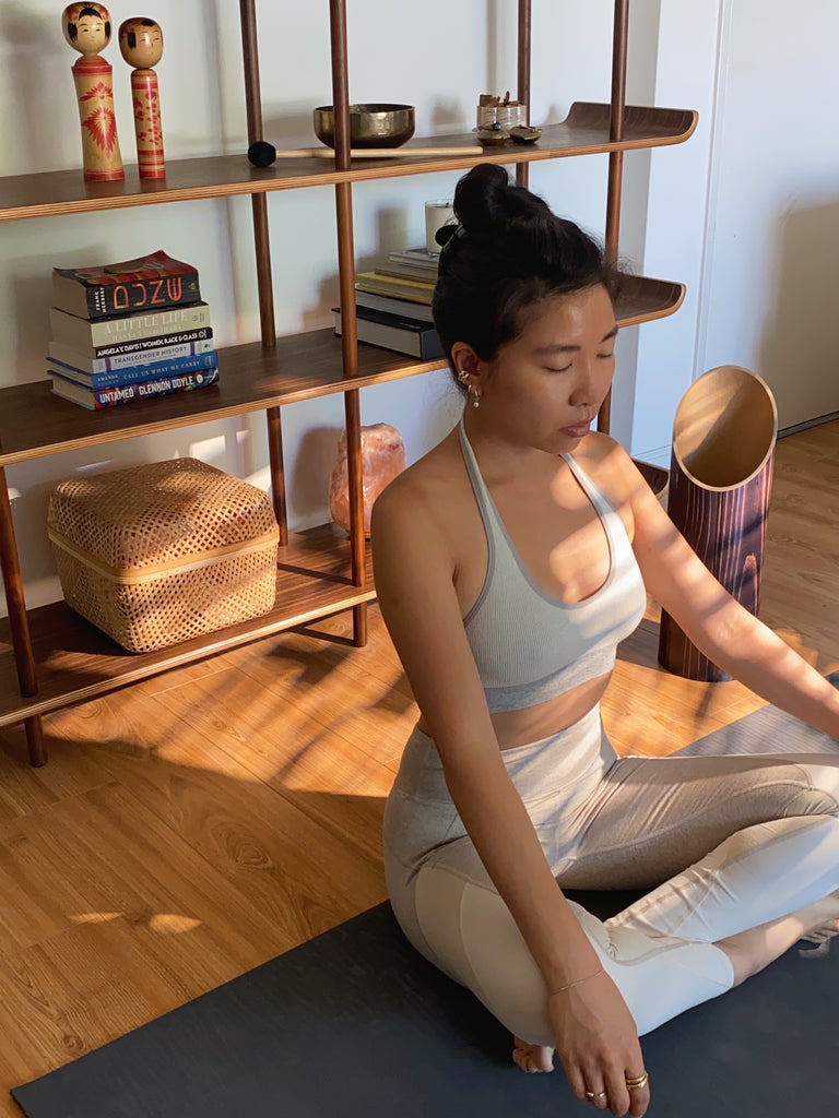 Person doing yoga at home beside their yoga mat storage