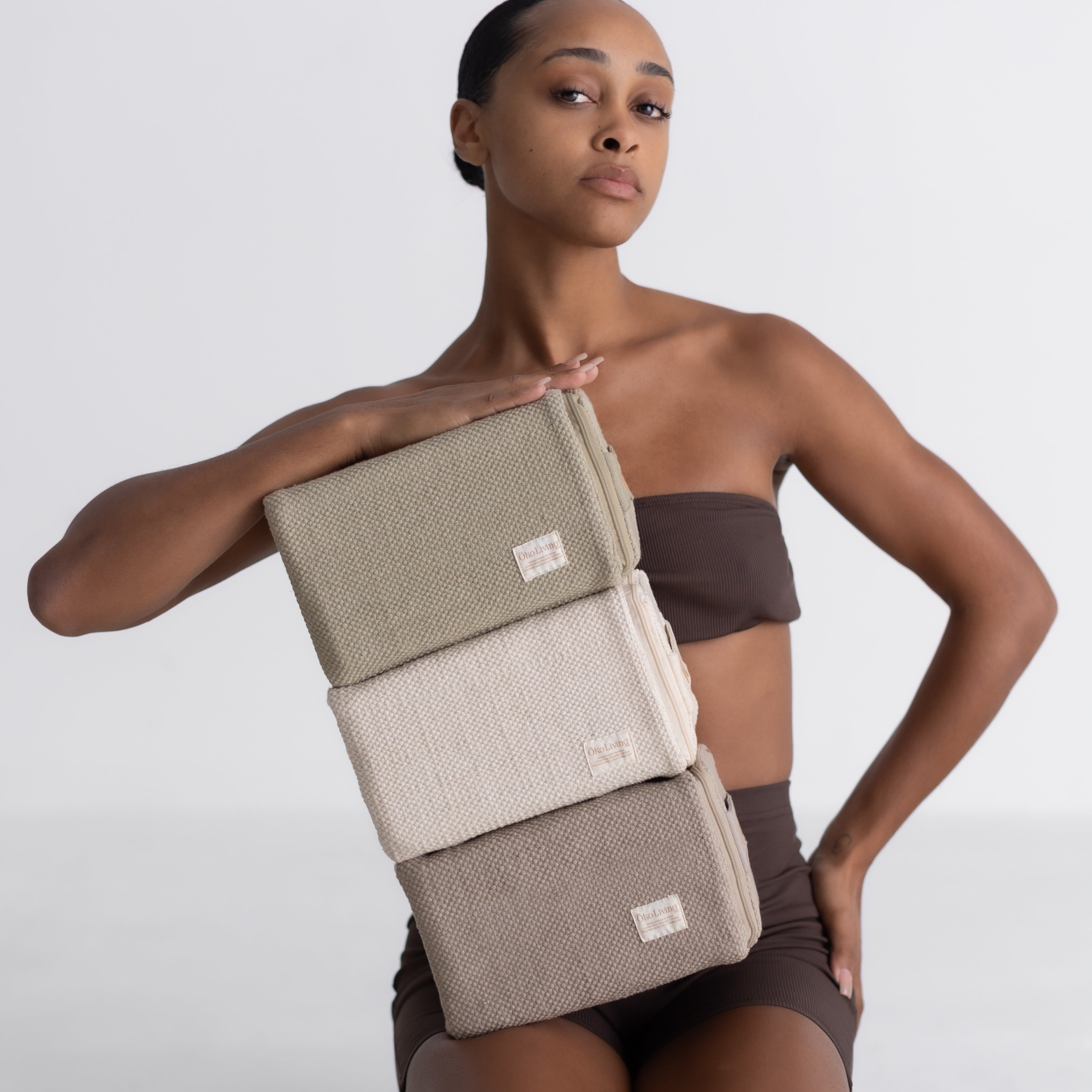 Woman holding cotton yoga blocks on a white background