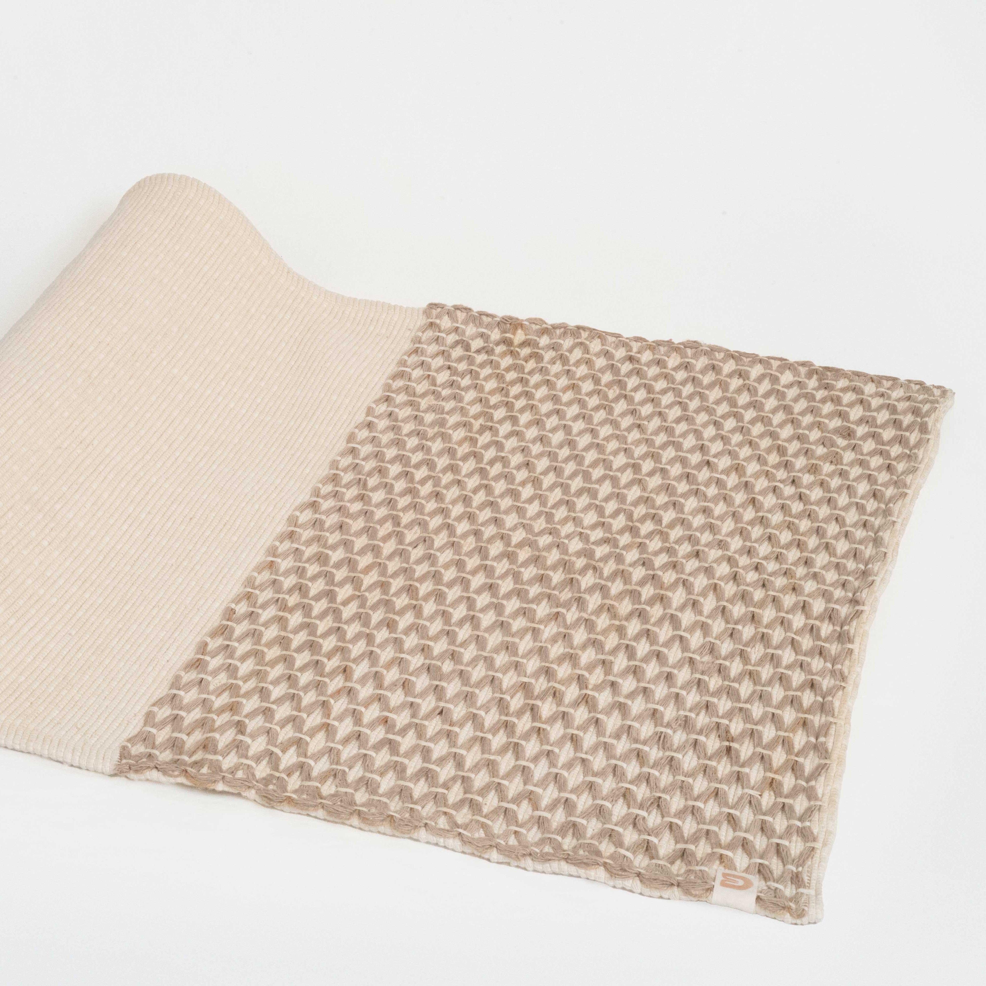 Folded beige and brown woven blanket on a white background