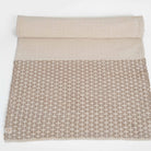 Textured beige blanket with geometric pattern on a white background