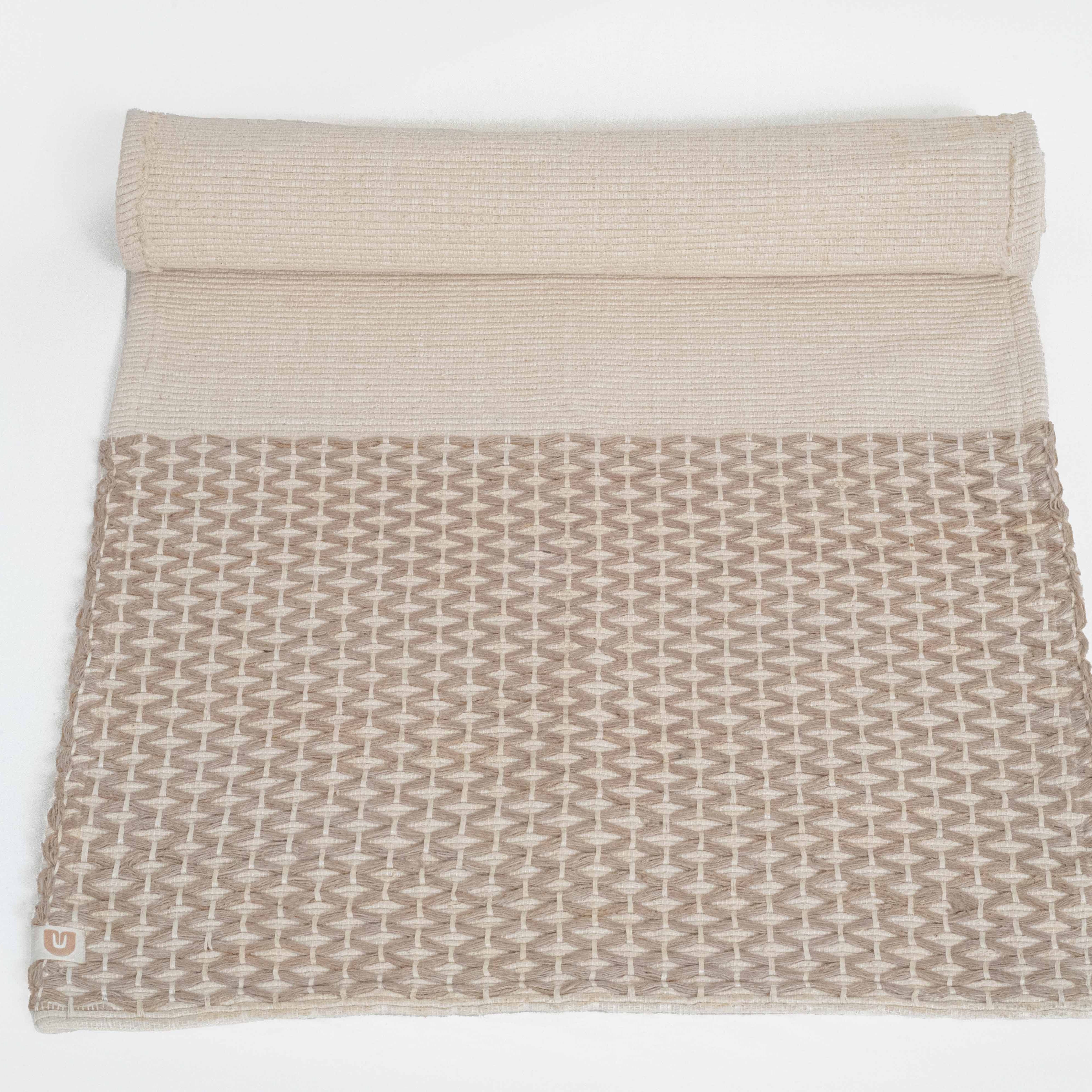Textured beige blanket with geometric pattern on a white background