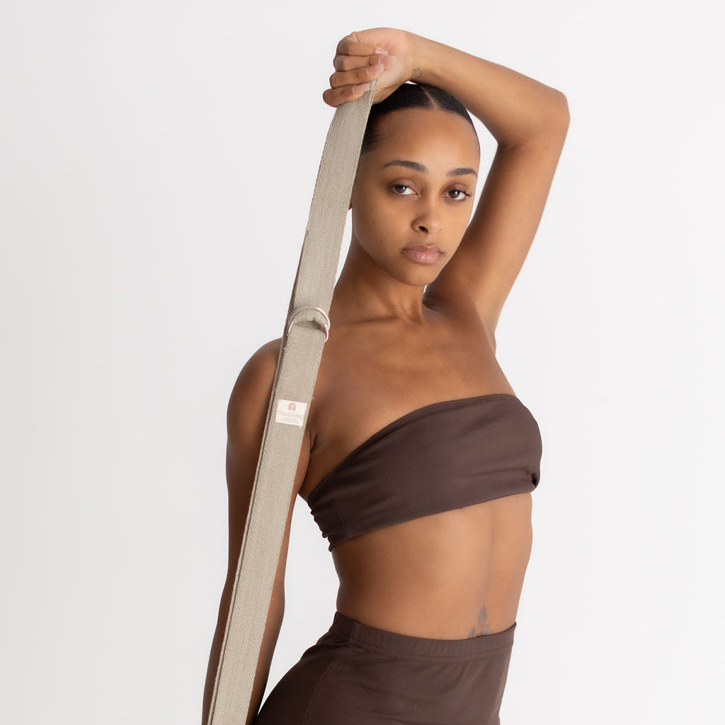 Woman holding a yoga strap against a white background