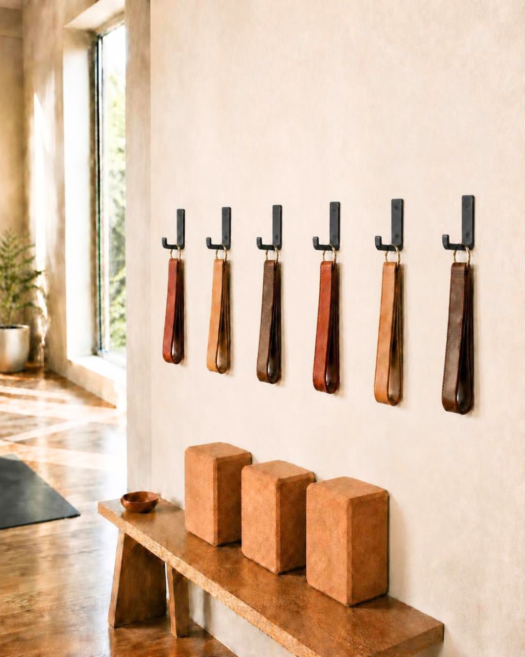 Yoke Hooks holding yoga straps on a yoga studio wall