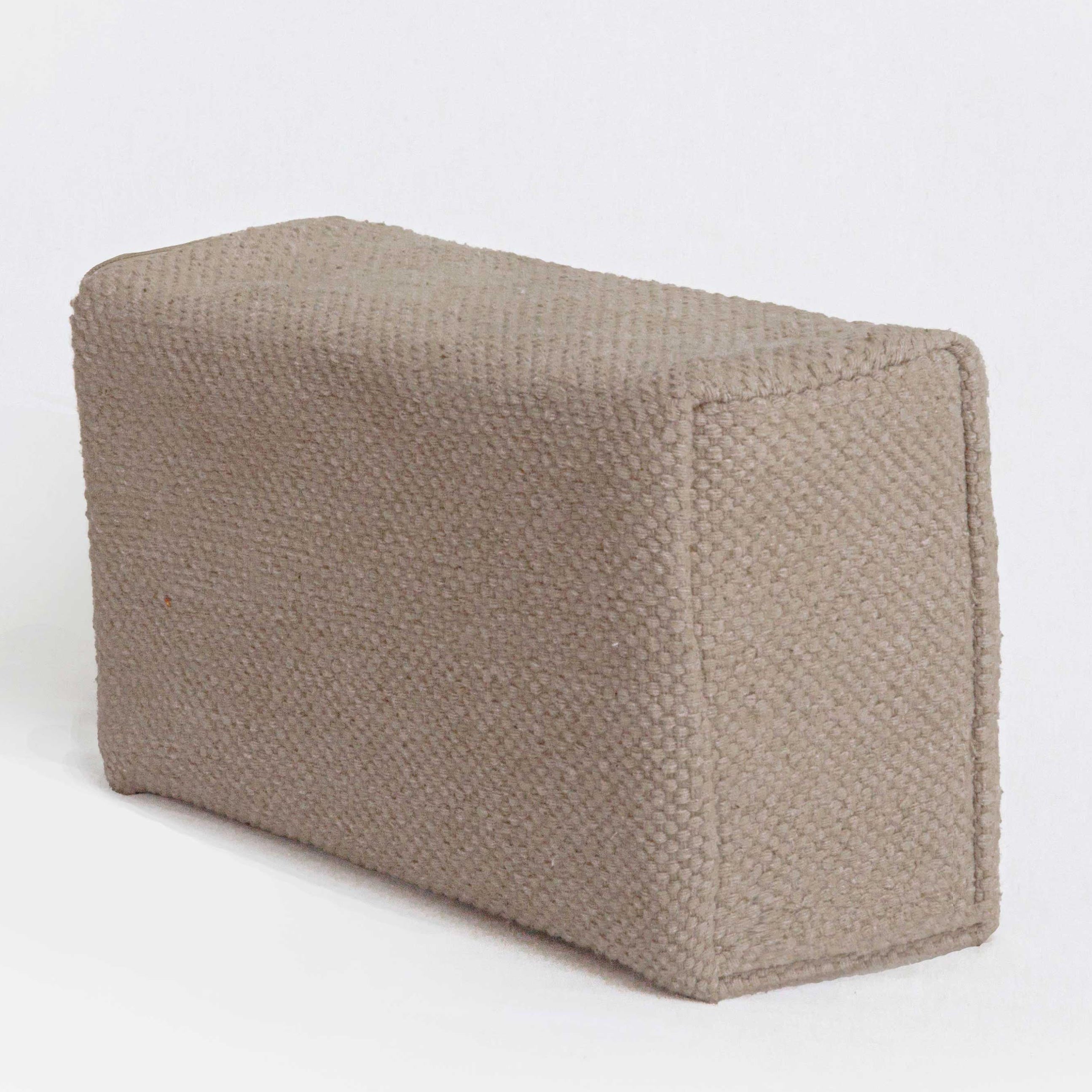 Textured beige yoga block on a white background