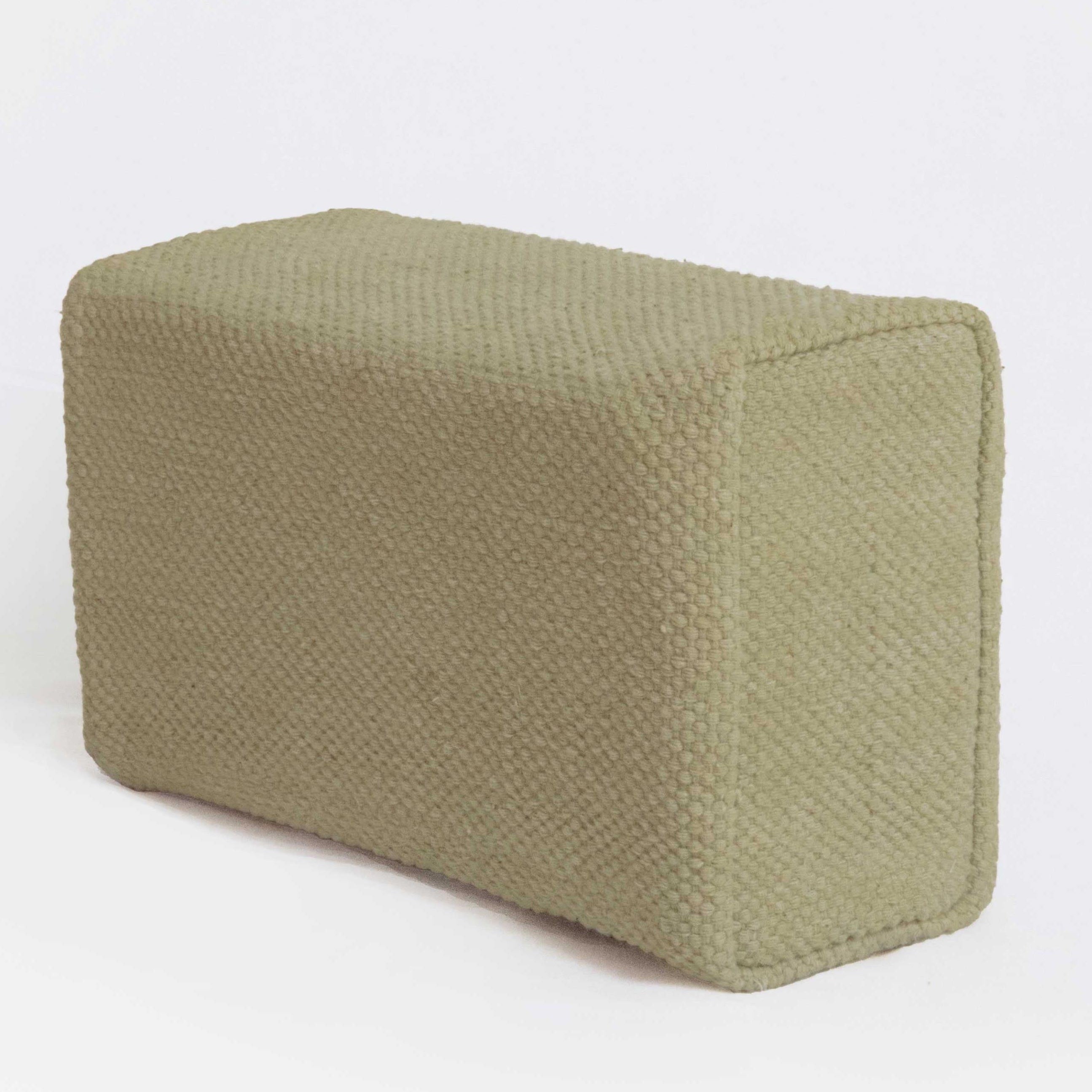 Green fabric yoga brick on a white background