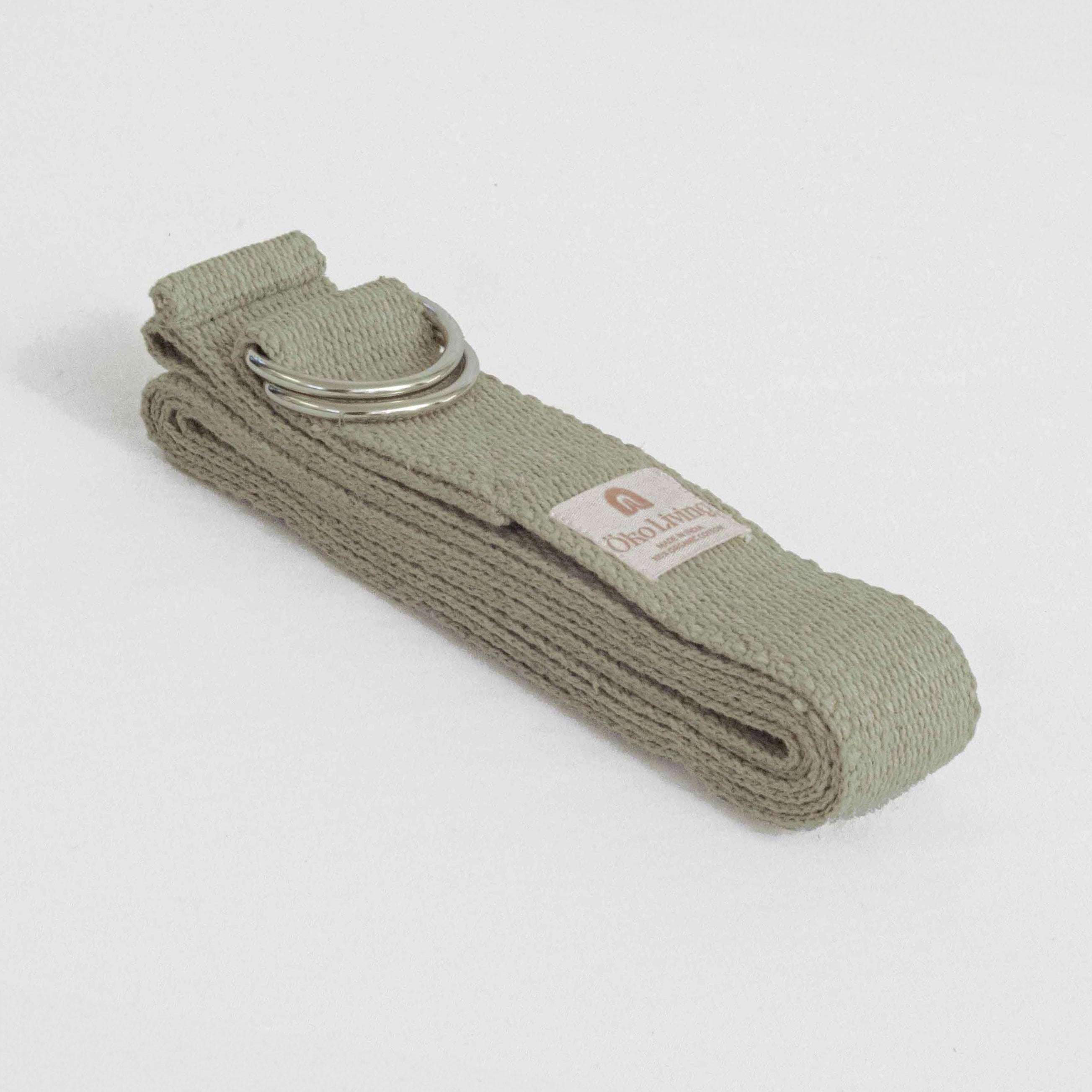 Green yoga belt with a metal ring on a light gray background