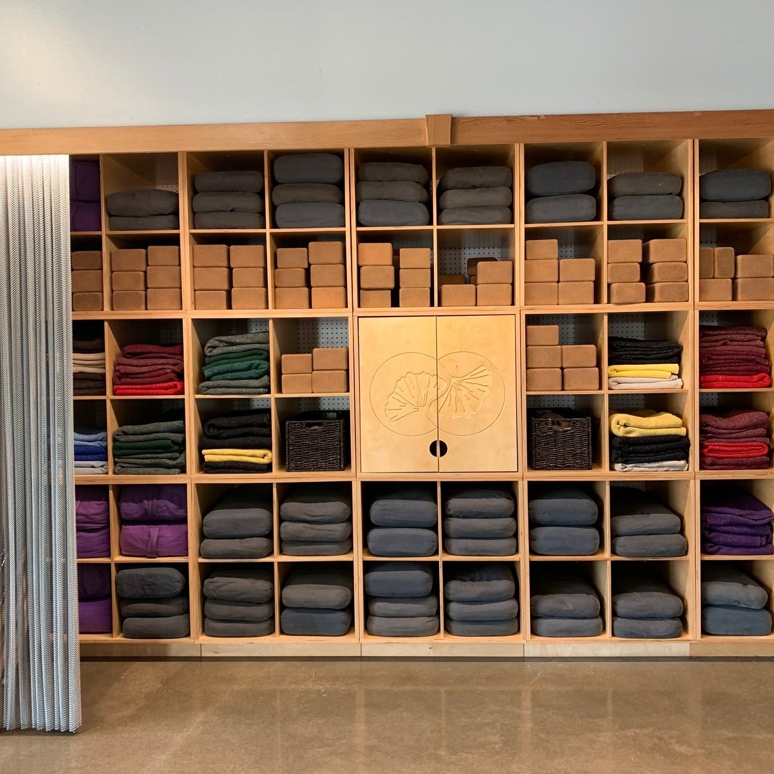 Shelves of mats, blocks and bolsters in yoga studio stock photo - OFFSET